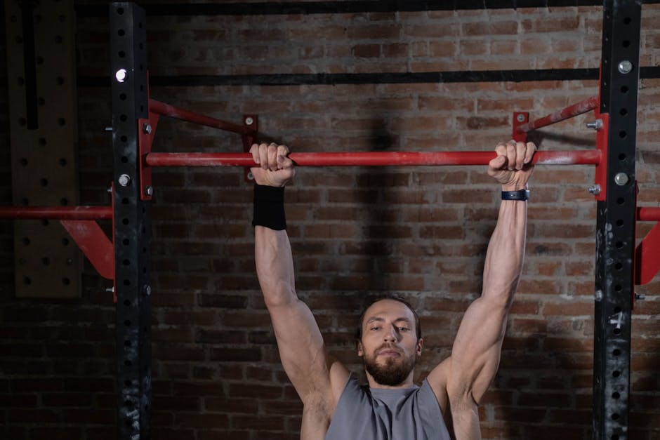 Man exercising on pull-up bar in gym, showcasing strength and fitness