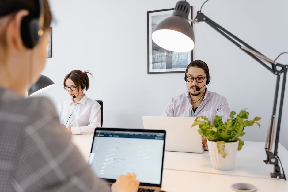 Equipo de atención al cliente trabajando en una oficina moderna y luminosa